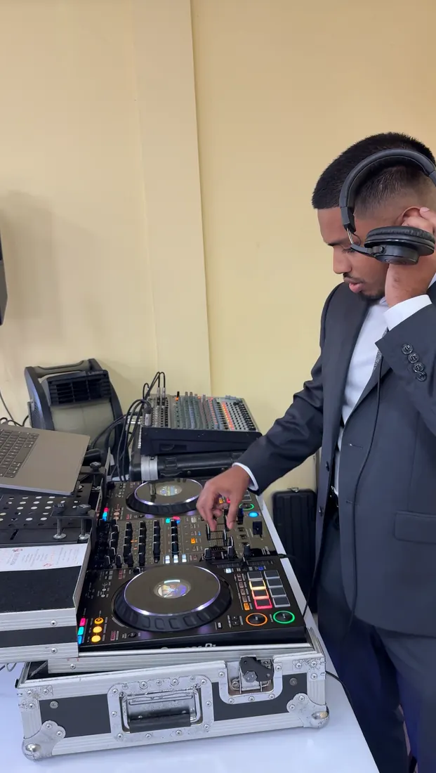 DJ Shadzy in a suit with headphones, cueing the next track