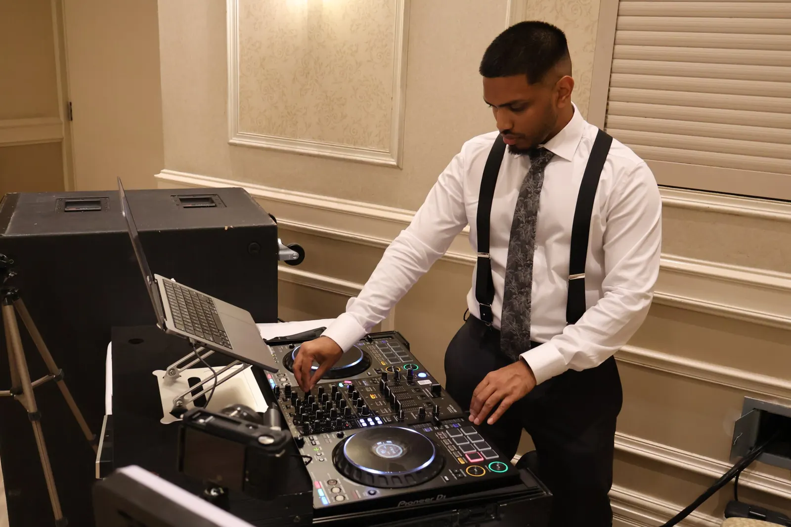 DJ Shadzy setting up his decks in a ballroom before a wedding reception